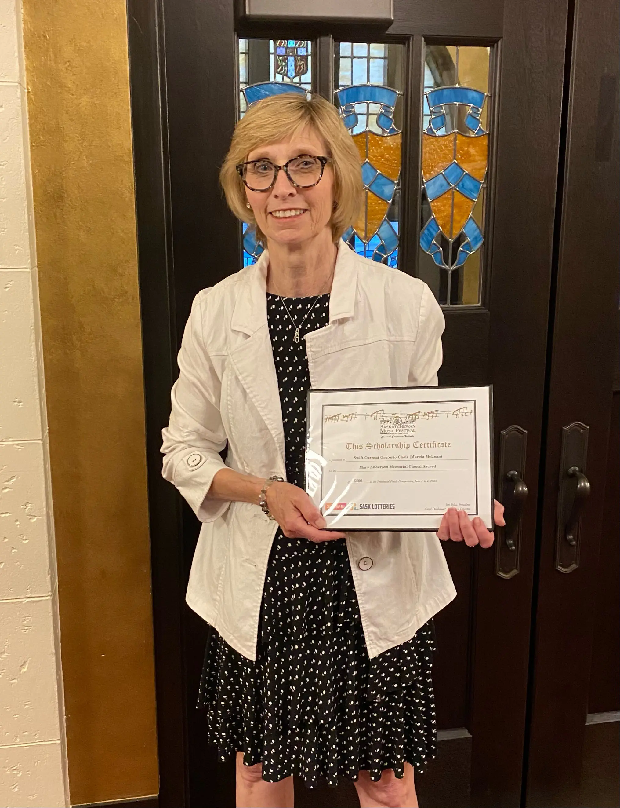 Marcia McLean, SCOC Artistic Director posing with the award certificate